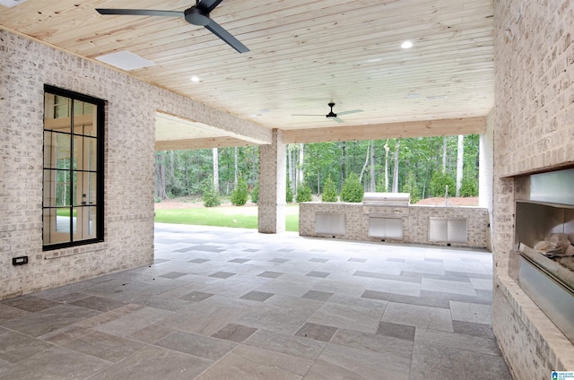 view of patio featuring area for grilling, ceiling fan, and an outdoor kitchen