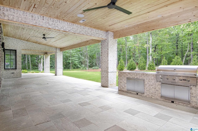 view of patio featuring area for grilling, ceiling fan, and exterior kitchen