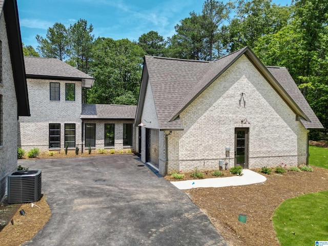 view of front of home with central air condition unit and a garage