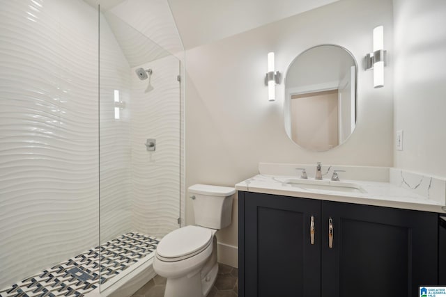 bathroom with tile patterned floors, vanity, toilet, and a tile shower