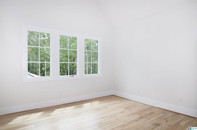 unfurnished room with light hardwood / wood-style flooring and vaulted ceiling