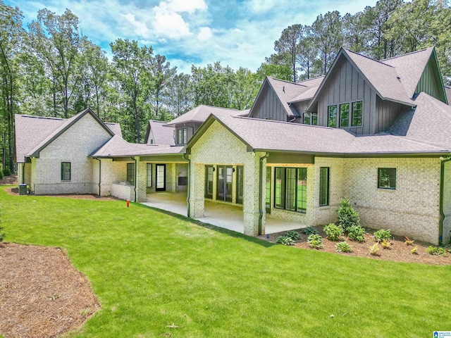 rear view of house with a lawn and a patio area