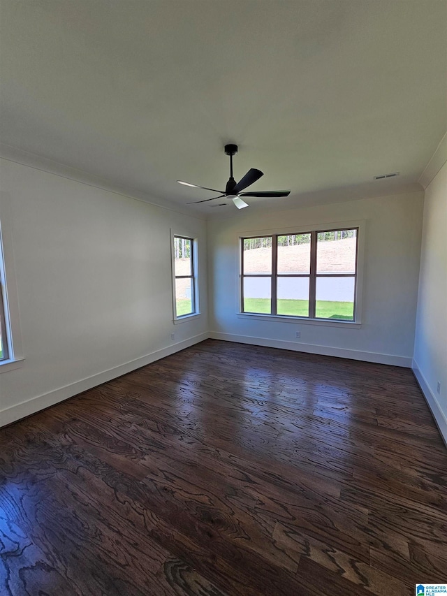 empty room featuring ceiling fan, dark hardwood / wood-style flooring, and crown molding