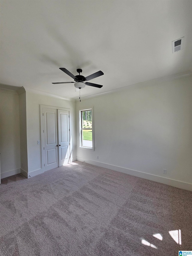 interior space featuring carpet, ceiling fan, and crown molding