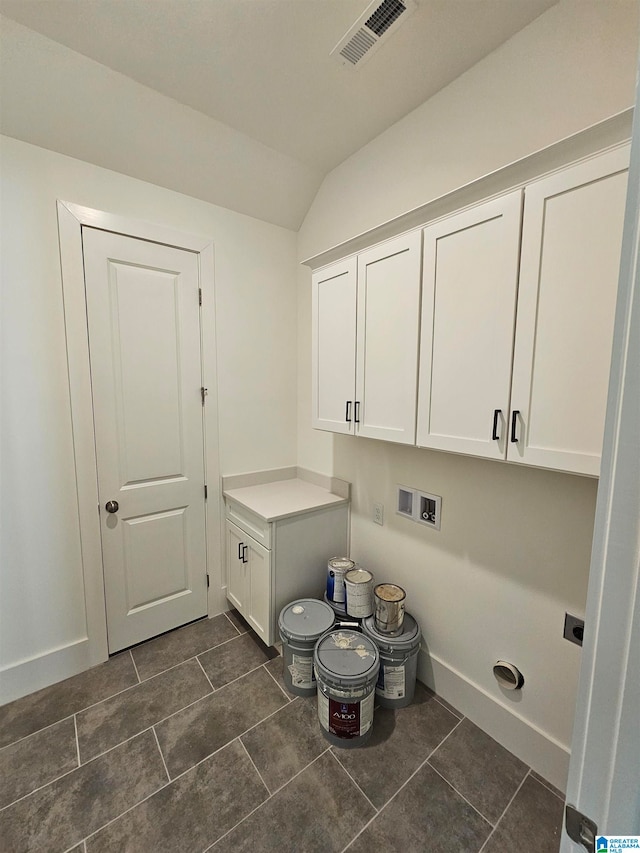 clothes washing area featuring cabinets, dark tile flooring, and hookup for a washing machine