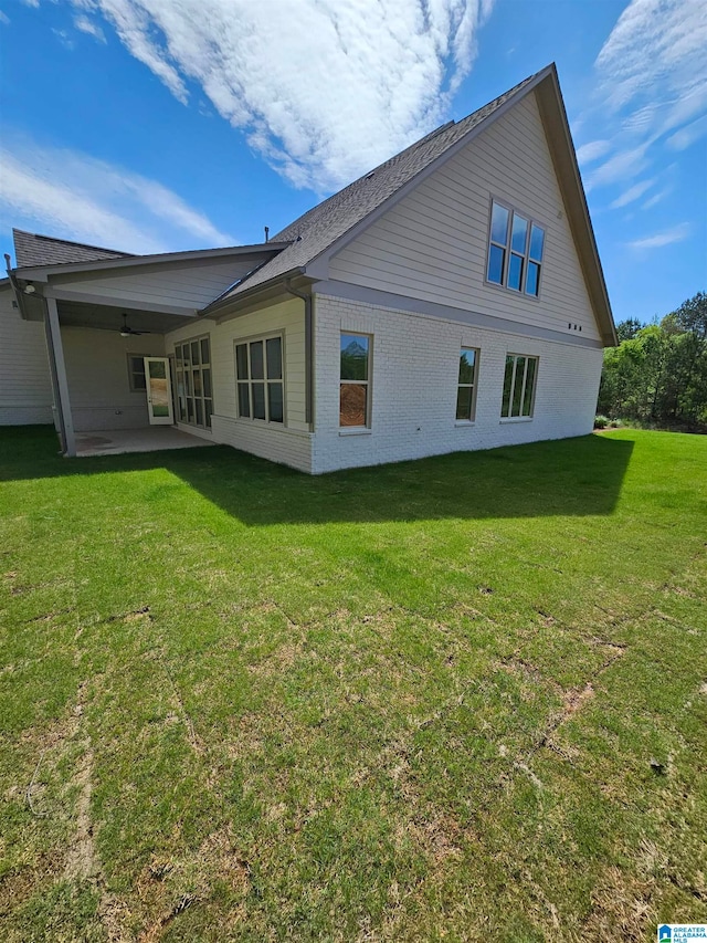 rear view of house featuring a lawn and a patio area
