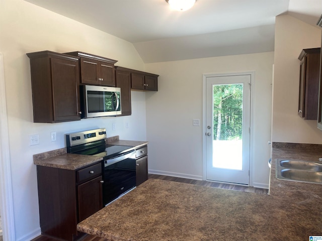 kitchen featuring dark brown cabinets, hardwood / wood-style flooring, lofted ceiling, and range with electric cooktop