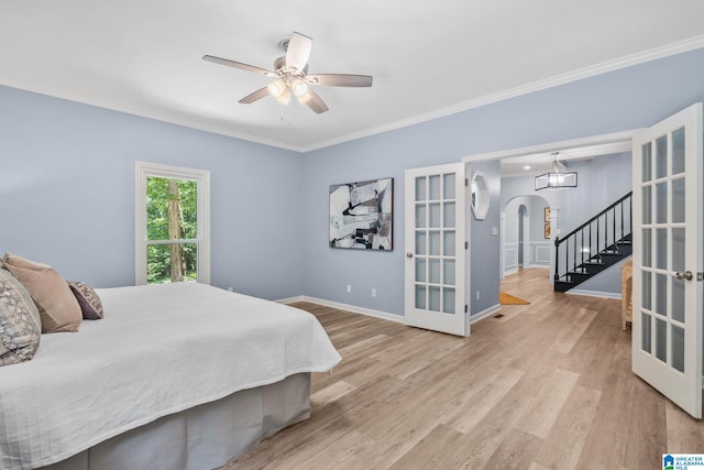 bedroom with crown molding, light hardwood / wood-style floors, french doors, and ceiling fan