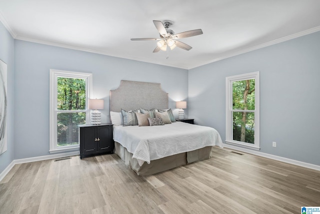 bedroom with light hardwood / wood-style flooring, ornamental molding, and ceiling fan