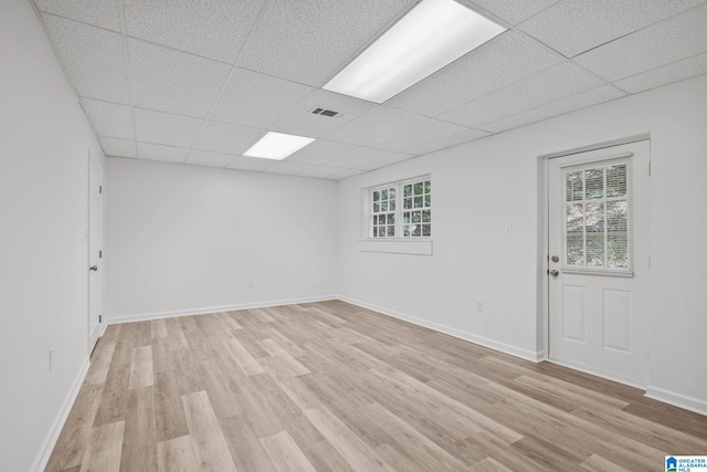 unfurnished room featuring a drop ceiling and light hardwood / wood-style flooring