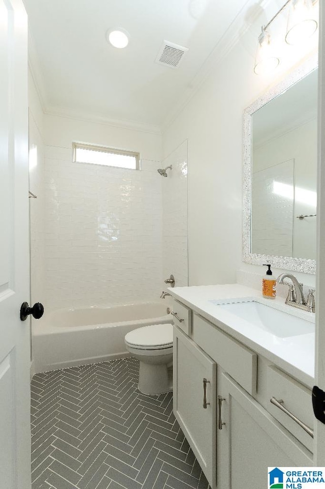 full bathroom with tiled shower / bath, vanity, crown molding, toilet, and tile patterned floors