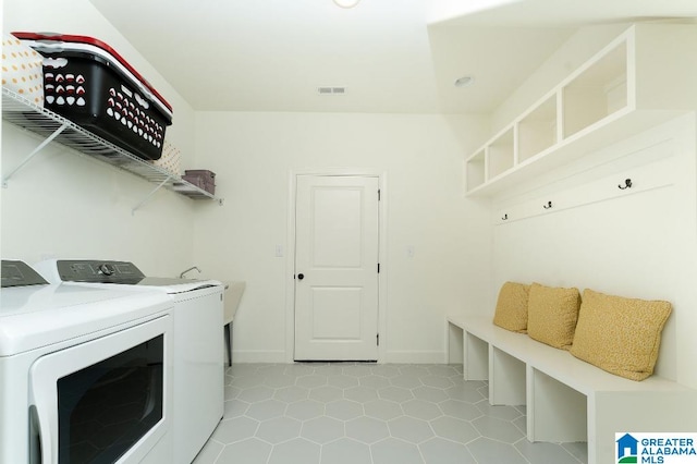 laundry room with independent washer and dryer and light tile patterned floors