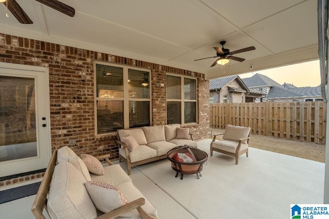 patio terrace at dusk with ceiling fan and an outdoor living space with a fire pit