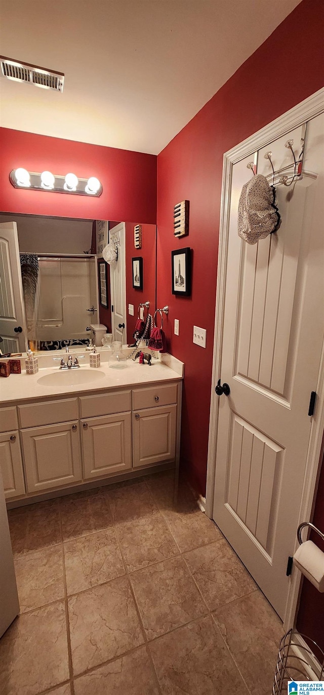 bathroom with tile floors, double sink, and vanity with extensive cabinet space