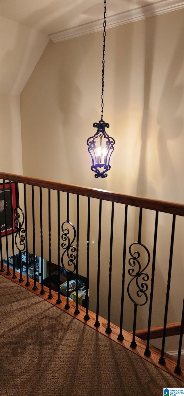 staircase featuring a notable chandelier, vaulted ceiling, carpet, and ornamental molding