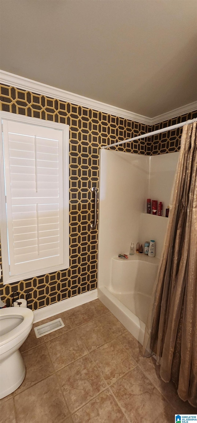 bathroom featuring tile flooring, ornamental molding, a shower, and toilet