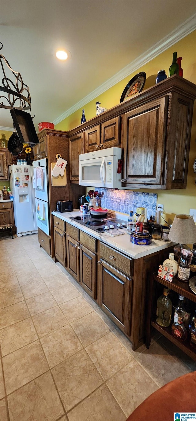 kitchen featuring dark brown cabinets, white appliances, light tile floors, and crown molding