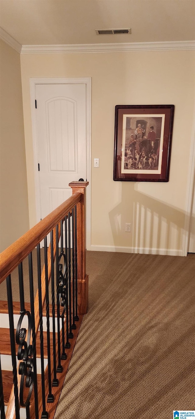 stairway with dark carpet and ornamental molding