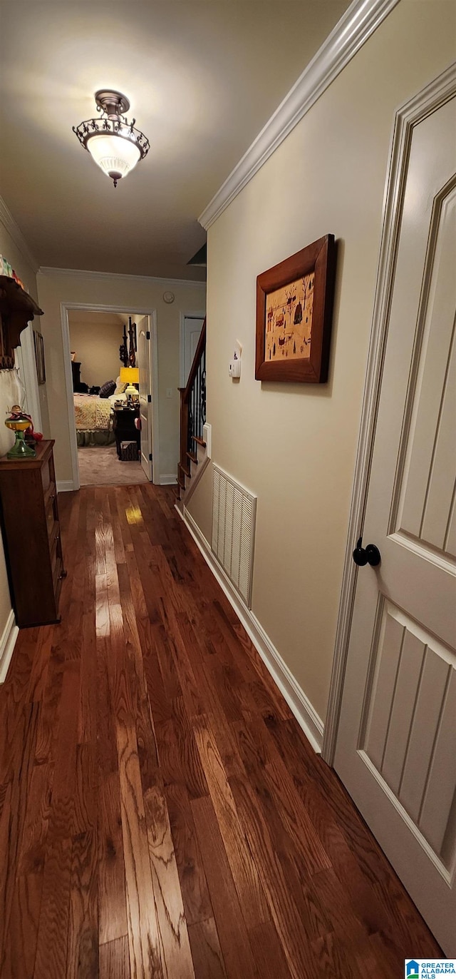 hall with wood-type flooring and crown molding