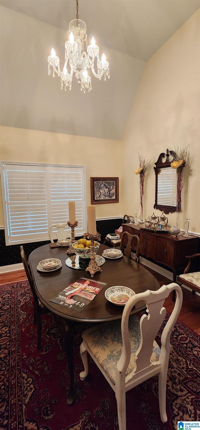 dining room featuring an inviting chandelier, hardwood / wood-style flooring, and lofted ceiling