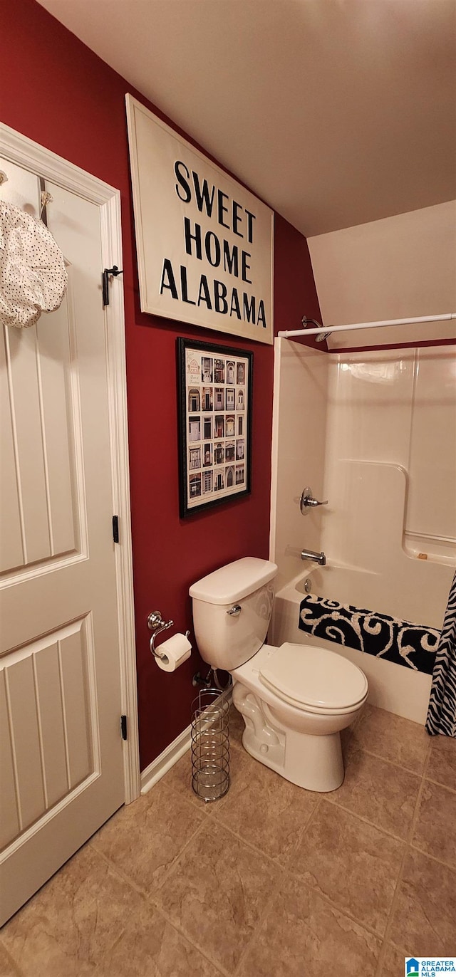 bathroom featuring toilet, tile floors, and tub / shower combination