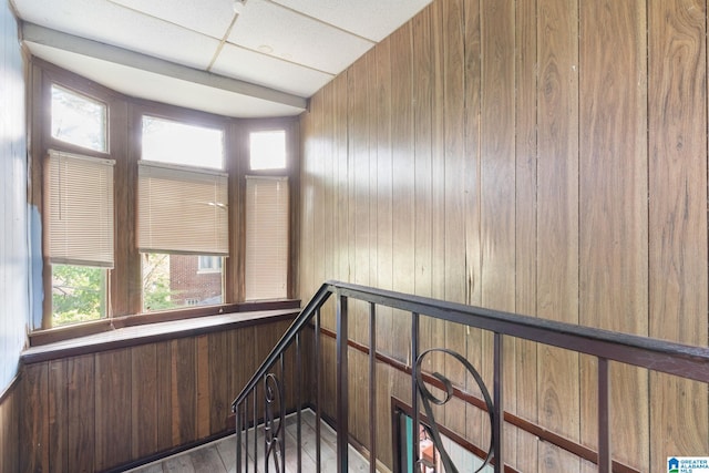 stairs with wood-type flooring and wood walls