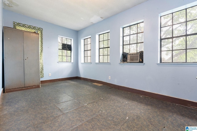 tiled empty room featuring a healthy amount of sunlight and a textured ceiling