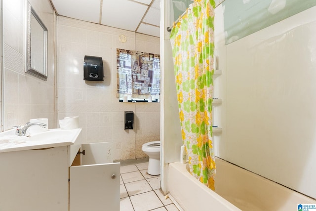 full bathroom featuring tile flooring, tile walls, shower / tub combo with curtain, toilet, and vanity