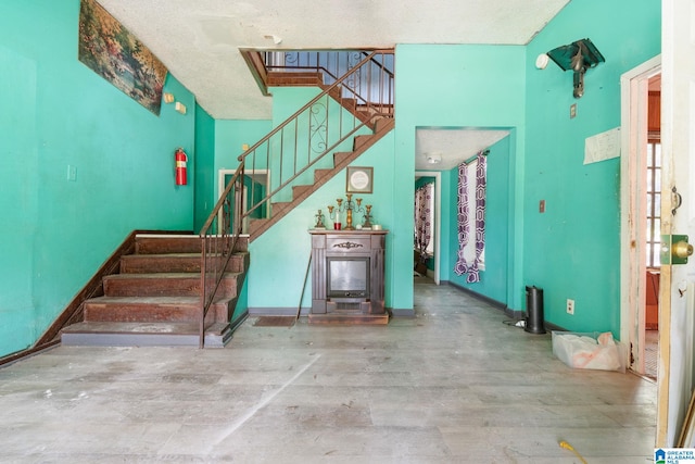 stairway with a textured ceiling and hardwood / wood-style floors