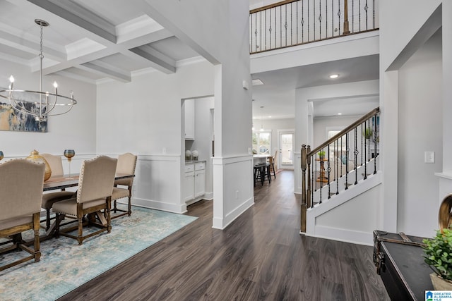 dining area featuring coffered ceiling, beamed ceiling, a chandelier, and dark wood-type flooring