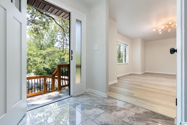 doorway to outside featuring light wood-type flooring and a chandelier