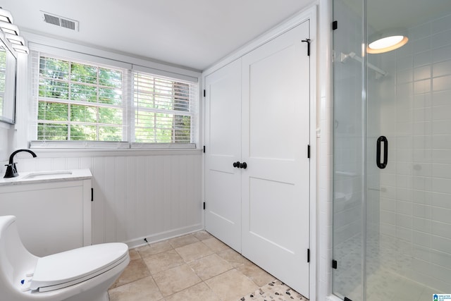 bathroom with toilet, tile patterned floors, an enclosed shower, and sink