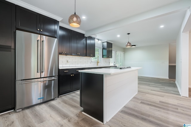 kitchen featuring high quality fridge, a center island, light hardwood / wood-style floors, and decorative light fixtures