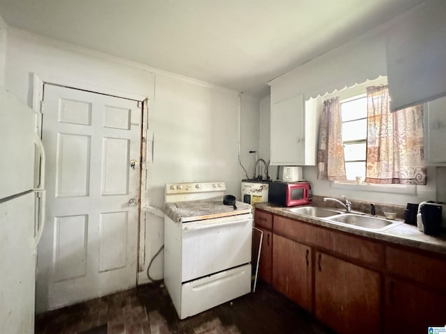 kitchen featuring sink, white cabinets, and white appliances