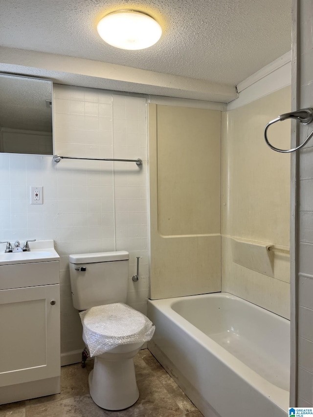 full bathroom featuring a textured ceiling, vanity, toilet, and tile walls