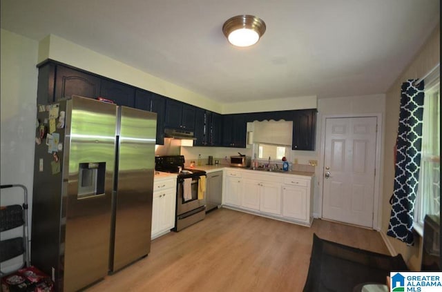 kitchen featuring sink, stainless steel appliances, light hardwood / wood-style floors, and white cabinetry