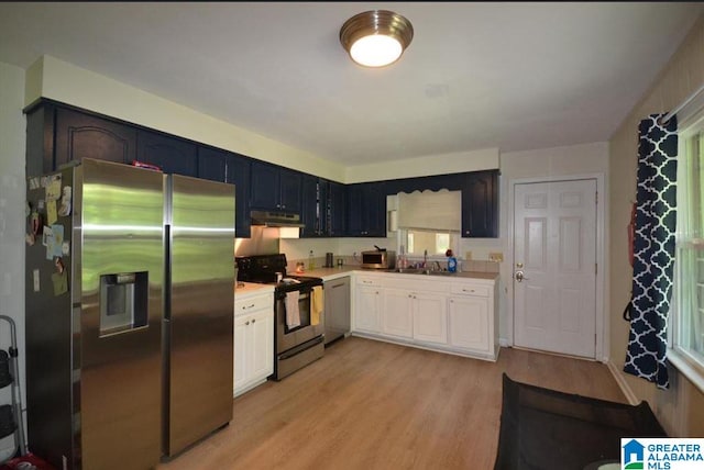 kitchen featuring appliances with stainless steel finishes, white cabinetry, sink, and light hardwood / wood-style flooring