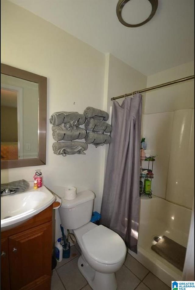 bathroom with walk in shower, vanity, toilet, and tile floors