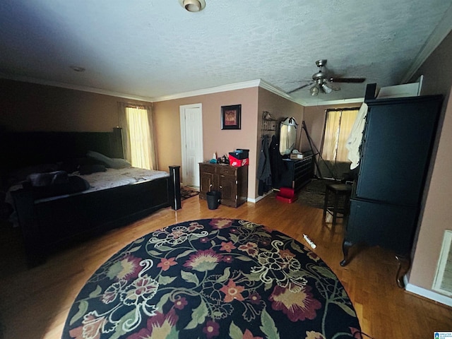 bedroom with ceiling fan, ornamental molding, hardwood / wood-style floors, and a textured ceiling