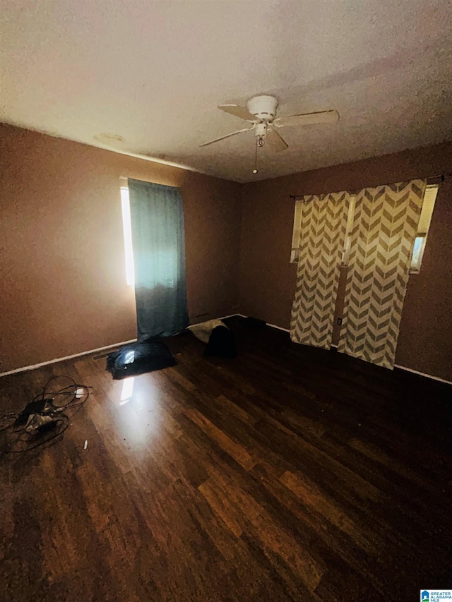 spare room with dark wood-type flooring and ceiling fan