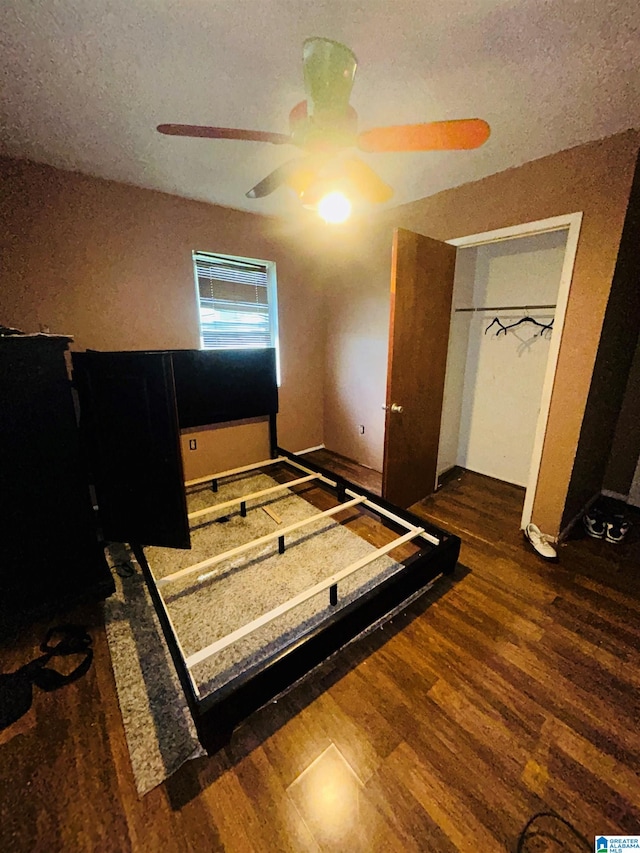 bedroom featuring ceiling fan, dark hardwood / wood-style floors, a closet, and a textured ceiling