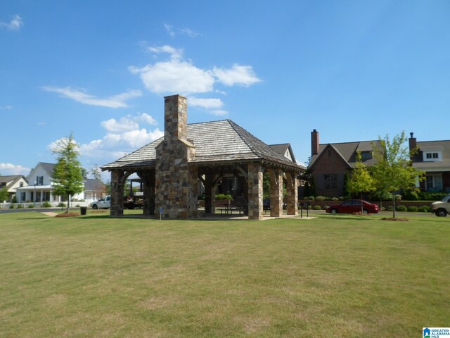 rear view of house with a yard and a gazebo