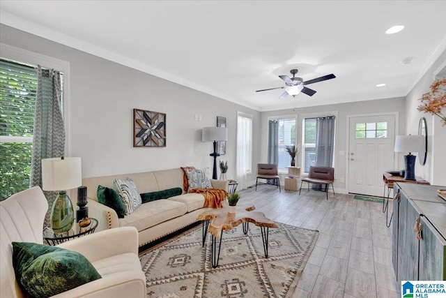 living room with light hardwood / wood-style flooring, ceiling fan, and ornamental molding