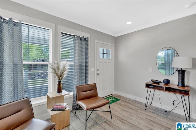 sitting room featuring ornamental molding, a wealth of natural light, and light hardwood / wood-style flooring