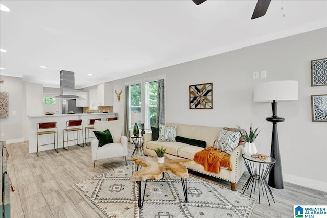 living room featuring light hardwood / wood-style floors and ceiling fan