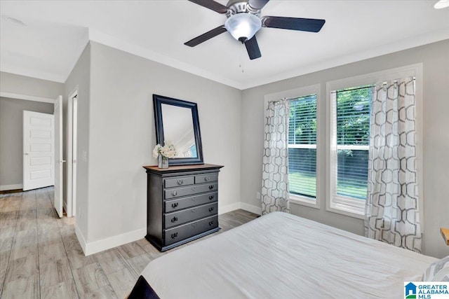 bedroom with light hardwood / wood-style flooring, ceiling fan, and crown molding