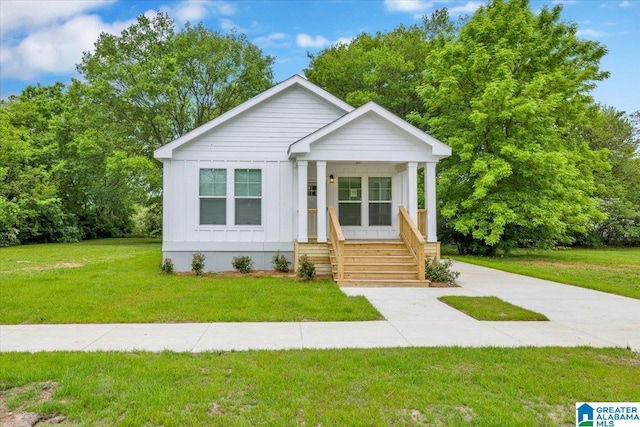 view of front of house with covered porch and a front lawn