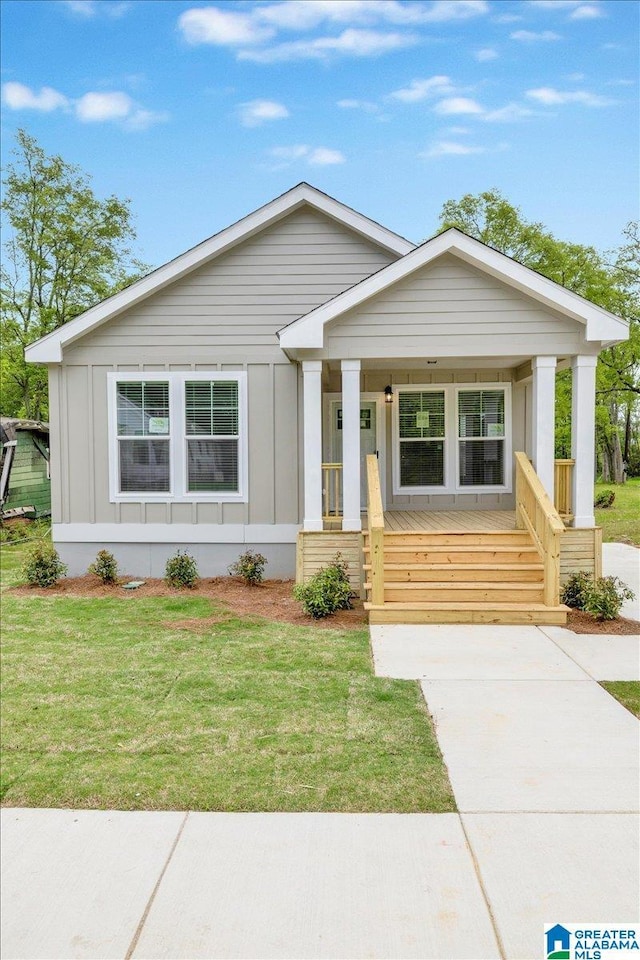 view of front of home featuring covered porch and a front lawn