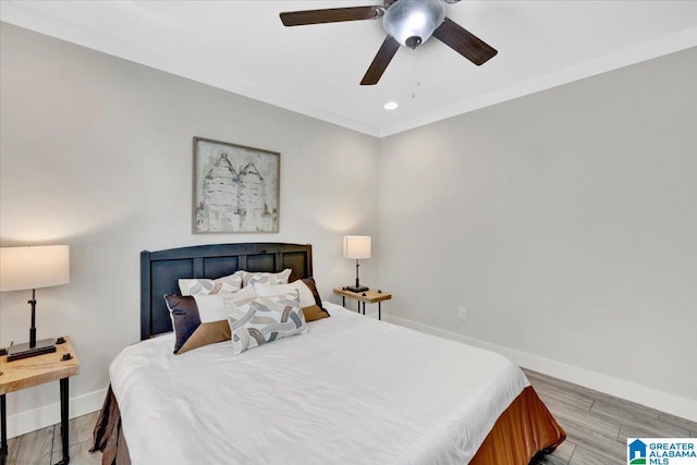 bedroom with light hardwood / wood-style floors, ceiling fan, and ornamental molding