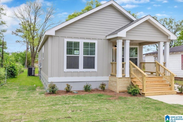 view of front of home with central AC unit and a front yard